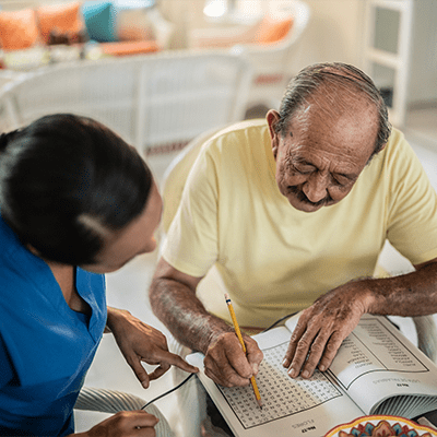 healthcare worker helping senior with corssword puzzle