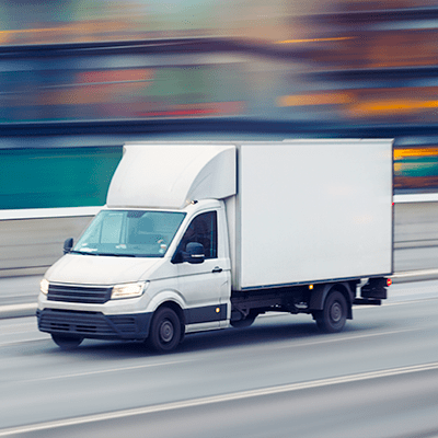 a moving-truck looks to be on the highway, the background is blurred to depict its speed