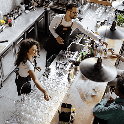 birds eye view of two bartenders waiting on customers ordering drinks at the bar