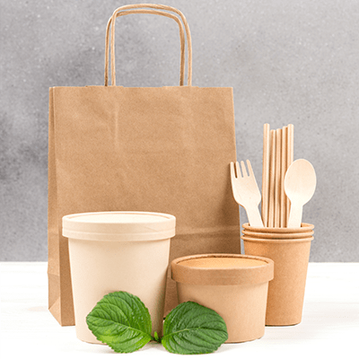 a minimalistic display of items such as bags, silverware, and containers all made with recyclable materials like wood, and bio-degradable paper