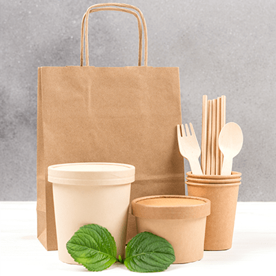 Sustainable Solutions a minimalistic display of items such as bags, silverware, and containers all made with recyclable materials like wood, and bio-degradable paper