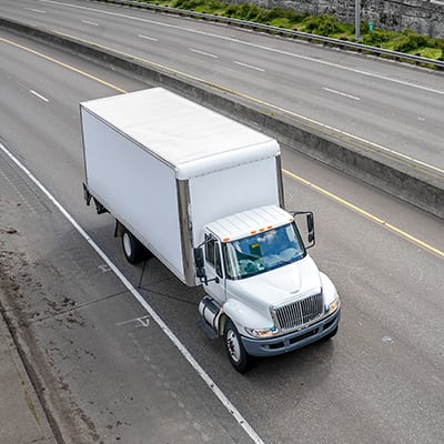 A white semi driving down the highway