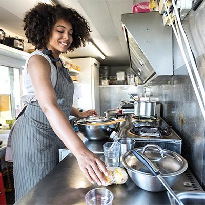 woman in an apron working happily in a food truck