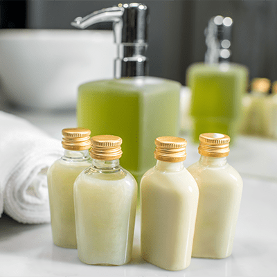 Assortment of hotel amenities including small bottles of toiletries on a bathroom counter.