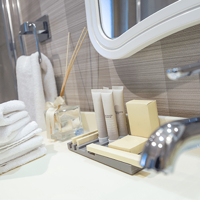 Hotel bathroom counter with neatly arranged amenities.