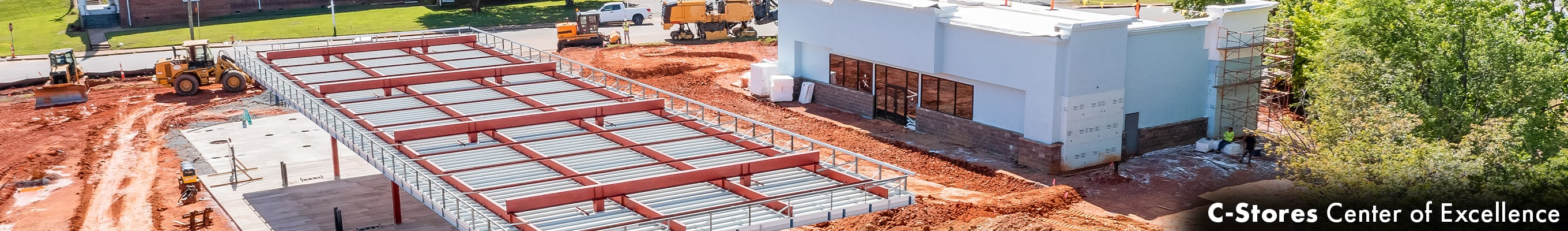 A construction site with the structural framework of a new building in progress, heavy machinery on site.